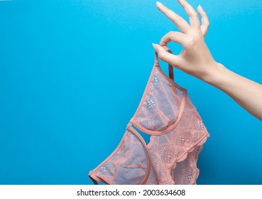 Treason banner template. Proof of treason. Female bra in a female hand on a blue background. Betrayal.
