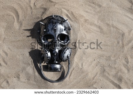 Treasure hunt at the beach scary and creepy horror cyborg gas mask helmet skull descovery buried scene in the sand for fun iconic halloween event party ghost game and storytelling background