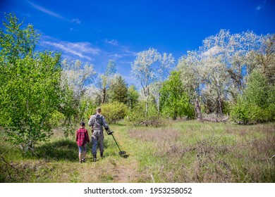 Treasure Hunter With Electronic Metal Detector Device Looking For Treasures With His Child