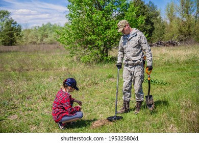 Treasure Hunter With Electronic Metal Detector Device Looking For Treasures With His Child