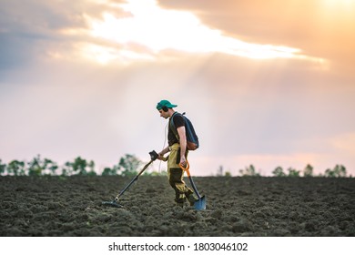 Treasure Hunter With Metal Detector In The Field.