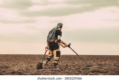 Treasure Hunter With Metal Detector In The Field.