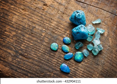 Treasure hunting. Mining for gems. Blue gems on rustic wooden table. Blue Turquoise, blue opals and apatite stones on a wooden table. Shallow depth of field. - Powered by Shutterstock