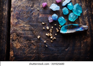 Treasure hunting. Mining for gems. Gold and gems on rough wooden surface. - Shutterstock ID 319325600