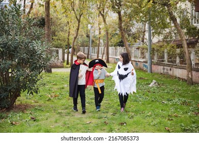 Treat or trick! Outdoor shot of group of children wearing carnival costumes for Halloween walking in the park with candies. Happy kids celebrating Halloween. - Powered by Shutterstock