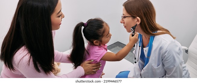 Treatment Deafness For Child In Playful Way. Positive Asian Little Girl Examining Doctor With Otoscope. Ear Exam