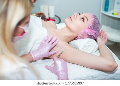 Treatment Of Hyperhidrosis. In The Cosmetologist S Office, Female Hands In Pink Gloves Inject A Young Woman In The Armpit. Healthy Body Concept, Self-care. Stop Sweating And Bad Smell