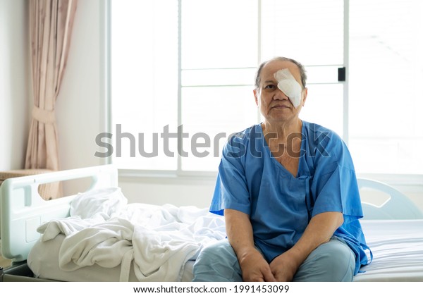 Treatment of post-operative\
cataract by the concept of caregiver An old Asian man put a\
protective shield over her eyes to cover the cover to protect\
during nap time.