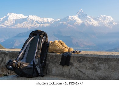 Trecking Or Hiking Equipment Set With Annapurna Mountain Range On Background. Bagpack, Hiking Shoes And Socks. Outdoor Activity Concept.