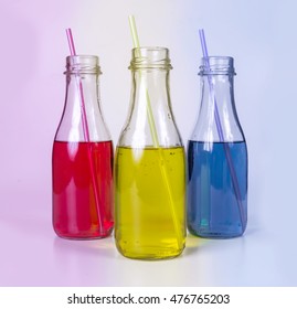 Tree colored cold drinks in colored lighting.