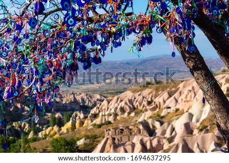 Tree full of turkish eyes with mountanins in the background in Goreme, Turkey