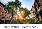 Tree lined block of historic apartment buildings on 10th Street in the Greenwich Village neighborhood of New York City NYC