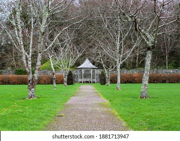 A tree lined path leading to a small gazebo in the beautiful gardens of Muckross Estate