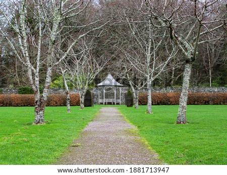 A tree lined path leading to a small gazebo in the beautiful gardens of Muckross Estate