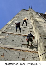 Tree mans and practicing abseiling in a building under construction.
