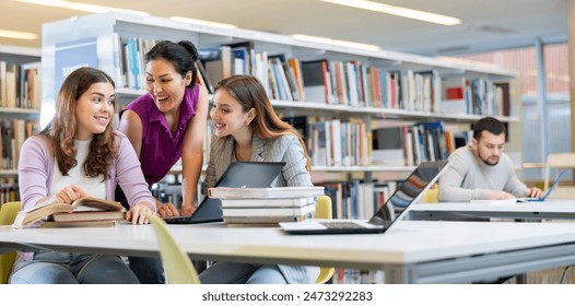 Tree positive young adult women learning at library together, working with laptop and books and smiling - Powered by Shutterstock