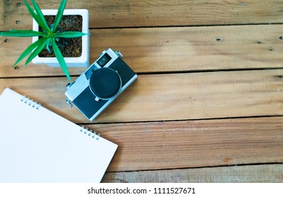 
Tree small , camera and Note Book on desk office wooden 