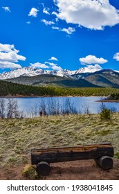 A tree trunk bench against the backdrop of the snow-capped Pikes Peak mountains, Colorado, USA