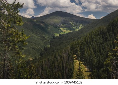 Tree-covered Vail Mountain With Blue Skies And Shadows Cast From The Clouds Above On A Summer Day In Vail, Colorado