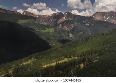 Tree-covered Vail Mountain With Blue Skies And Shadows Cast From The Clouds Above On A Summer Day In Vail, Colorado