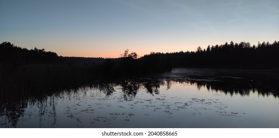 Treeline And Sunset Reflection On Water