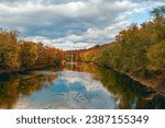 Сolorful trees along the banks of the Monocacy River and a railway bridge on the background. Frederick County. Maryland. USA