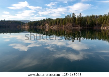 Trees and clouds reflected in Lake Britton in McArthur Burney Falls Memorial State Park, California, USA