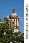 Trees in front of a bell tower in the Church and Convent of Santo Domingo de Guzman in Oaxaca, Mexico