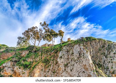 Trees And Mountain Home Against Blue Sky And Clouds In Laguna Beach California