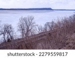 Trees and railroad tracks at an overlook along a frozen Lake Pepin on a spring day at Maiden Rock, Wisconsin USA.