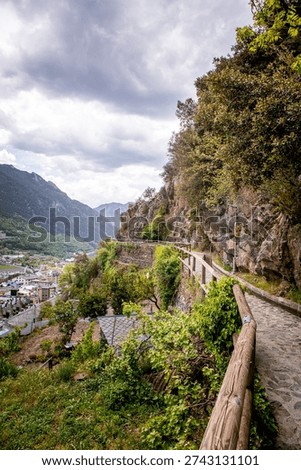 Trees and stone path on Rec del Sola trail in Andorra la Vella on a sunny day
