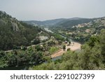 Treetops with leaves on the bank of the Mondego with aerial and panoramic view of the river beach of Reconquinho, Penacova PORTUGAL