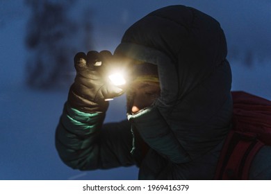Trekker with a headlamp walking in a snowy Riisitunturi National Park, Finland - Powered by Shutterstock