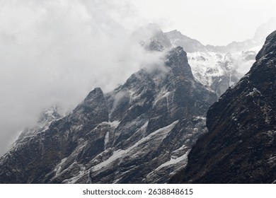 Trekking in the Annapurna mountain range reveals towering peaks covered in snow and clouds, showcasing the rugged beauty of Nepal’s landscape and the thrill of adventure