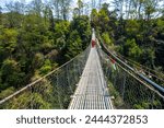 Trekking Enthusiasts Crossing a Suspension Bridge on Balthali Village Trek, Kathmandu Valley, Nepal