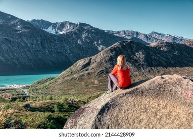 Trekking on Norway fiord - Besseggen trail. Tourist girl looking towards Memurubu (Gjende Lake).