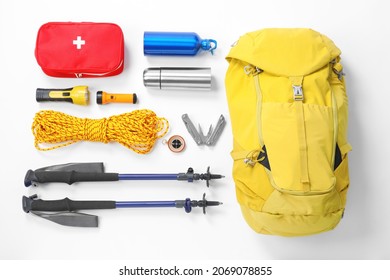 Trekking poles and other hiking equipment on white background, top view