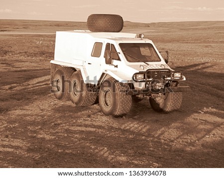 Trekol on the background of the tundra. Photo transport for the tundra. The car stands on the soil in the spring.