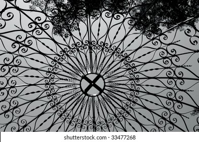 Trellised Gazebo Roof, In Longwood Gardens In Pennsylvania, Has Elegant Scroll Work In Black Wrought Iron.  Black And White Photo.