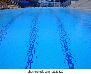 Trembling Surface Of An Olympic Size Swimming Pool In Empty Sport Arena