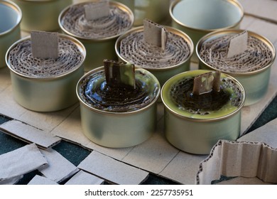 A trench candle is the name of a device for obtaining light, heating, drying clothes and cooking food in the form of a can, in which cardboard filled with wax or paraffin is placed. - Shutterstock ID 2257735951