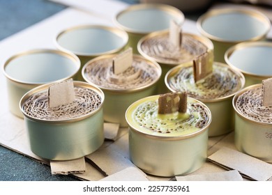 A trench candle is the name of a device for obtaining light, heating, drying clothes and cooking food in the form of a can, in which cardboard filled with wax or paraffin is placed. - Shutterstock ID 2257735961