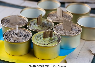 A trench candle is the name of a device for obtaining light, heating, drying clothes and cooking food in the form of a can, in which cardboard filled with wax or paraffin is placed. - Shutterstock ID 2257735967