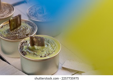 A trench candle is the name of a device for obtaining light, heating, drying clothes and cooking food in the form of a can, in which cardboard filled with wax or paraffin is placed. - Shutterstock ID 2257735975