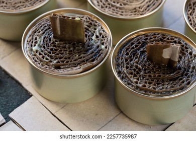 A trench candle is the name of a device for obtaining light, heating, drying clothes and cooking food in the form of a can, in which cardboard filled with wax or paraffin is placed. - Shutterstock ID 2257735987