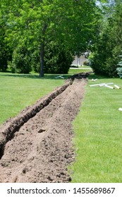 Trench Dug In The Green Yard By A Trench Digger For PVC Water Drainage Pipe