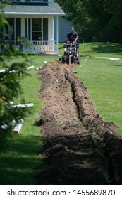 Trench Dug In The Green Yard By A Trench Digger For PVC Water Drainage Pipe