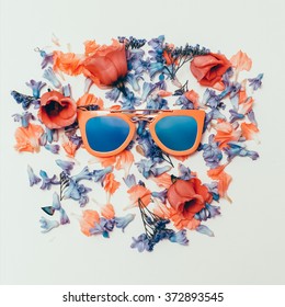 Trend Sunglasses on Flowers background. Summer is coming.