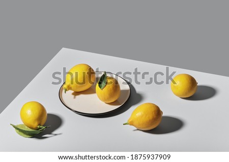 Trending colors of 2021. Yellow illuminating lemons on Ultimate gray tablecloth. Isometric view minimal still life.