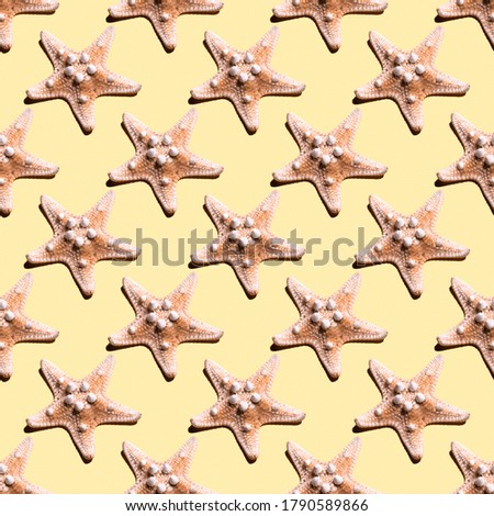 Trendly sunlight summer pattern made with starfish on yellow background. Good for wallpaper, textile background, poster, cover of book, post card.